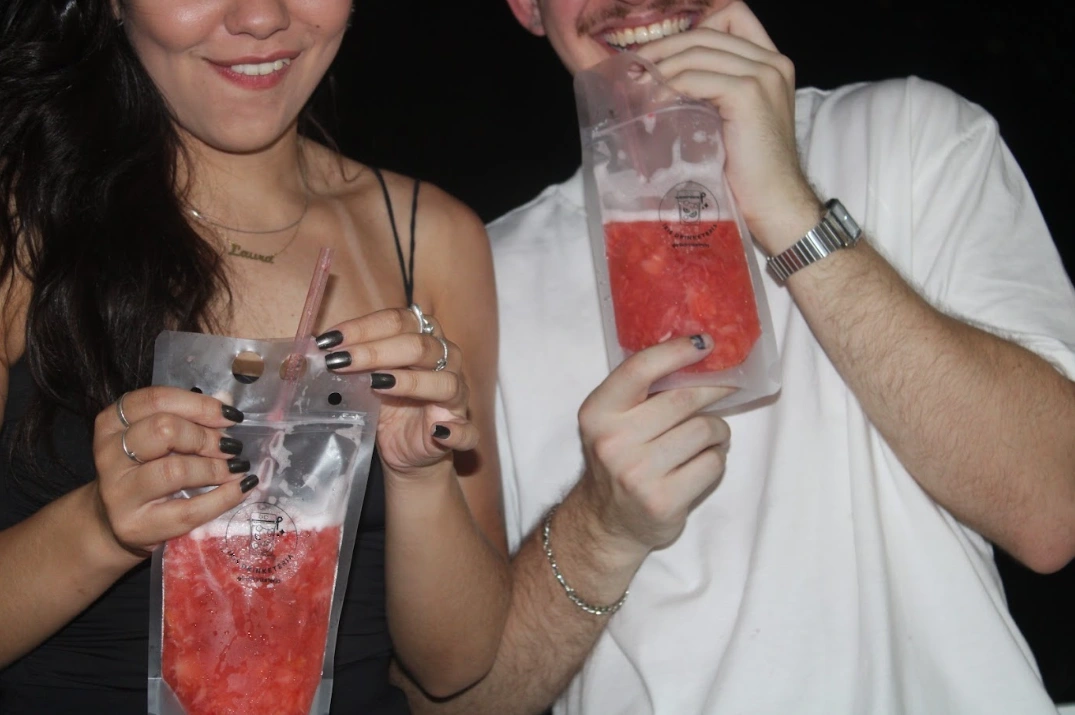 Convidados brindando com caipirinhas da Íris Drinketeria em embalagem personalizada