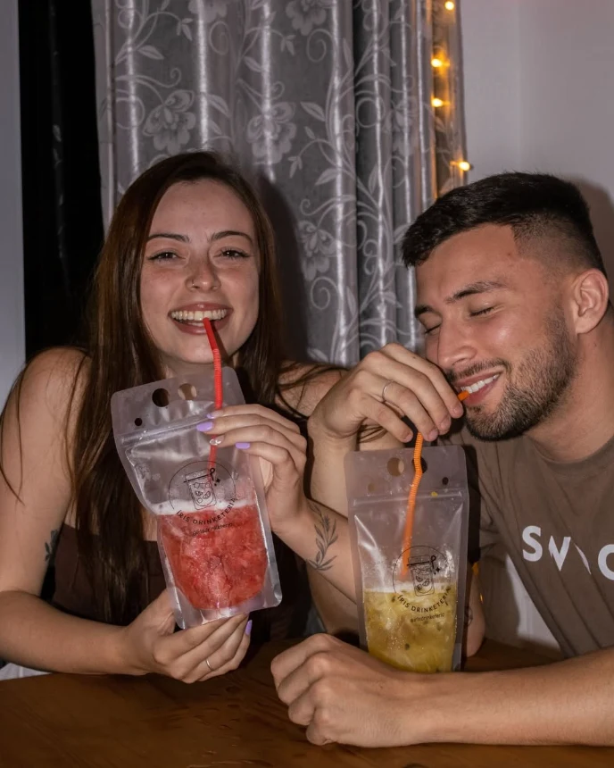 Casal segurando caipirinhas da Iris Drinketeria